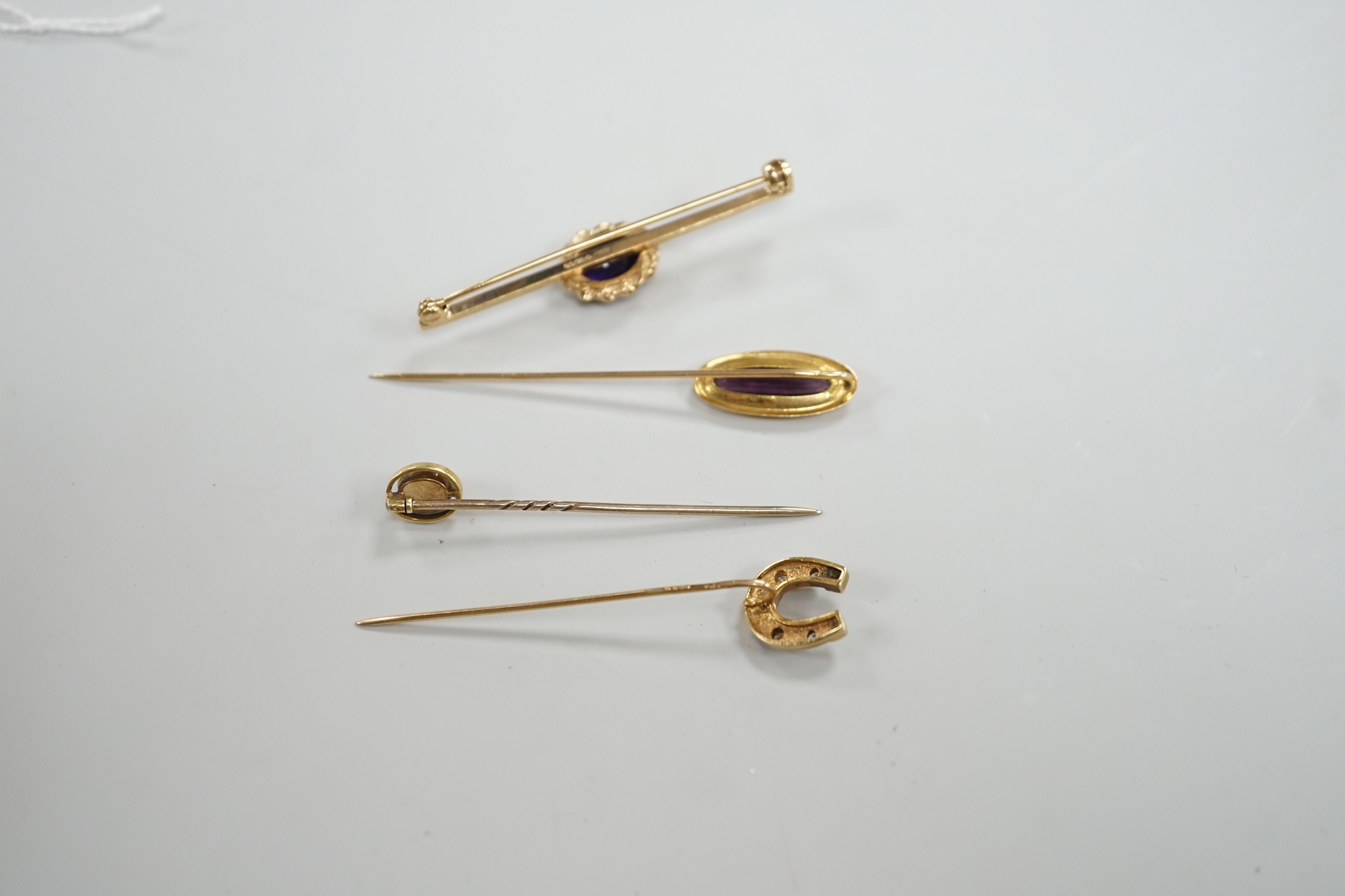 Three assorted yellow metal and gem set stick pins, including 9ct gold and diamond set horseshoe, 58mm and a modern 9ct gold and gem set bar brooch, gross weight 9.2 grams.